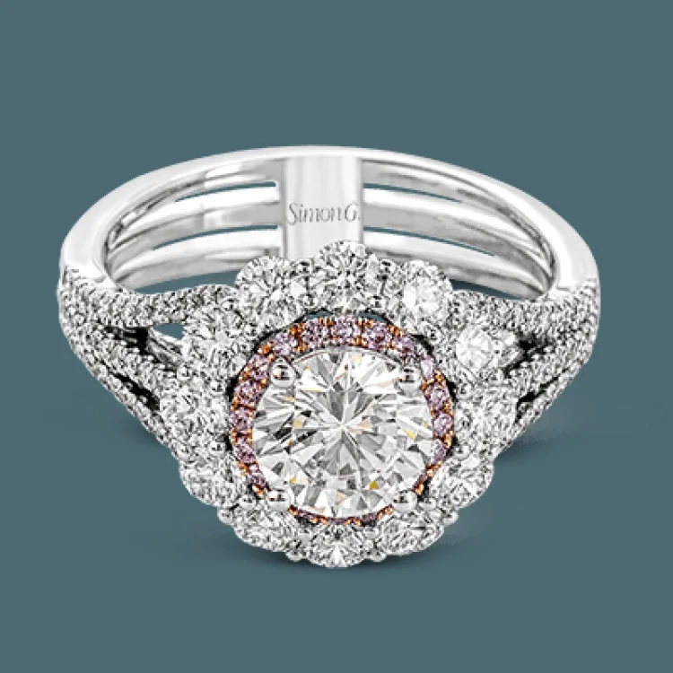 ladies rings for casual wear -This lovely white gold contemporary ring features a dazzling halo of .10 ctw pink diamonds accented by 1.13 ctw round cut white diamonds.