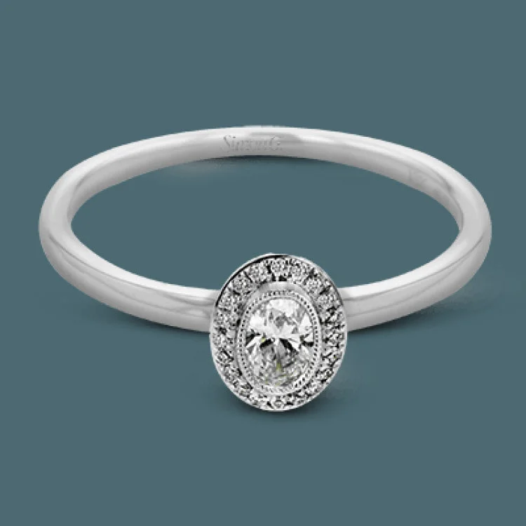 ladies rings classic timeless appeal -This exquisite, minimalist white gold ring features a halo containing .05 ctw of round white diamonds encircling a .17 ctw oval shaped white diamond