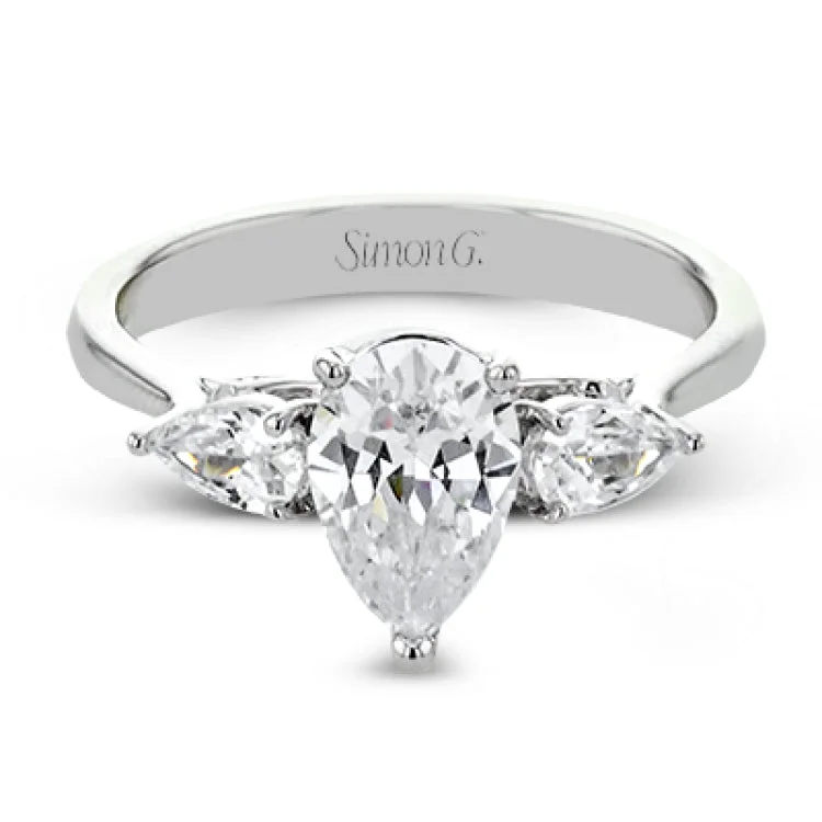 ladies rings sleek modern style -This distinctive three stone ring is new take on a classic style, with .45 ctw of pear shaped side diamonds highlighting the pear shaped center stone.