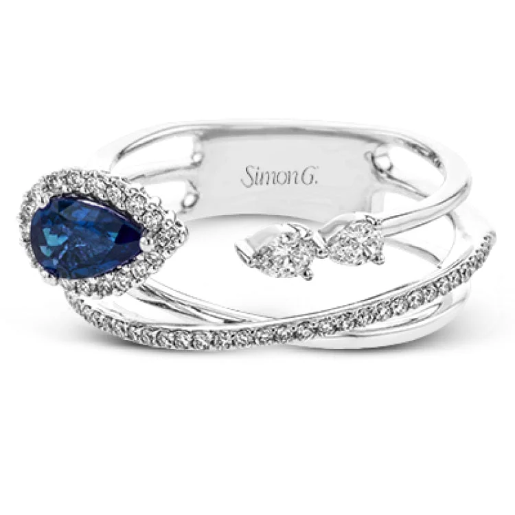 ladies rings silver minimalist style -This modern 18k white gold ring features a crossover design set with a .42 ct blue sapphire, .12 ctw of pear shaped diamonds, and .20 ctw of round diamonds.